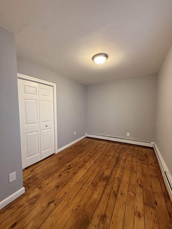 69 Hollis Street, Unit 13 Worcester, MA 01610 - Photo 4 of 8 a view of empty room with wooden floor
