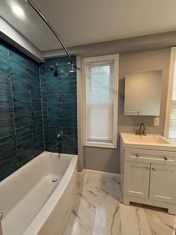 a bathroom with a bathtub sink and mirror