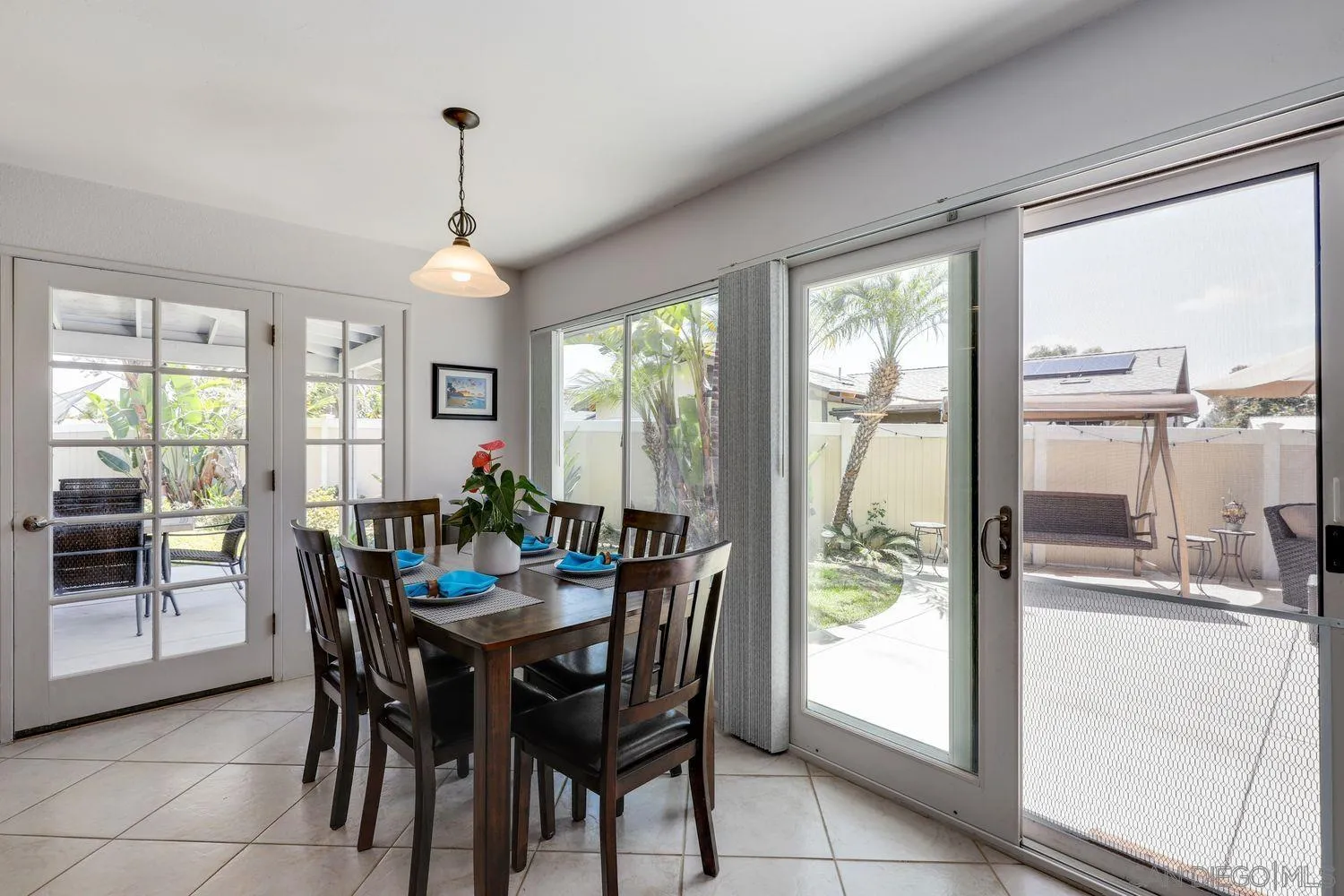 8531 Menkar Road San Diego, CA 92126 - Photo 12 of 37 a dining room with furniture a chandelier and wooden floor