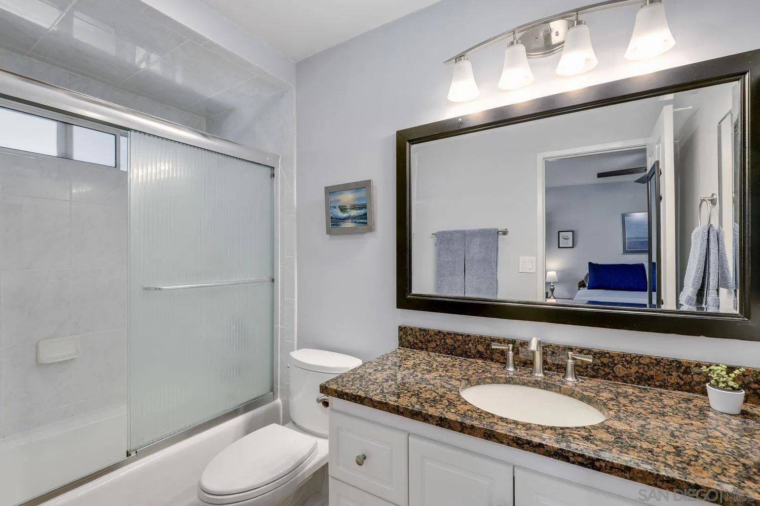 8531 Menkar Road San Diego, CA 92126 - Photo 15 of 37 a bathroom with a granite countertop sink toilet a mirror and shower
