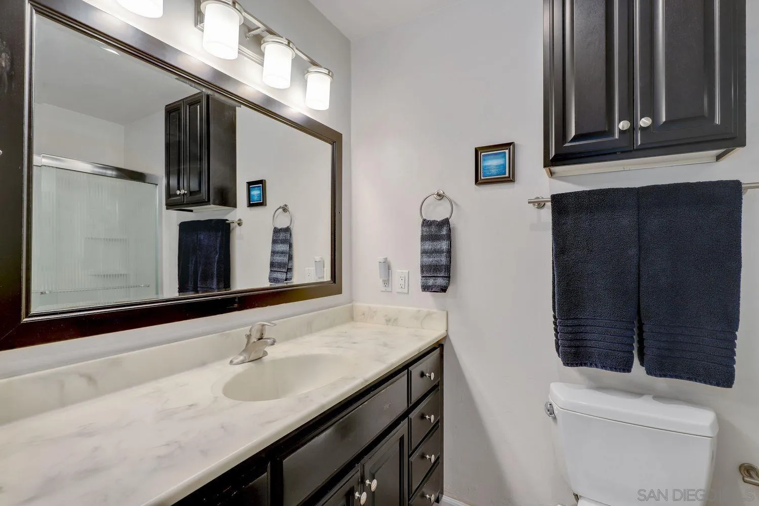 8531 Menkar Road San Diego, CA 92126 - Photo 18 of 37 a bathroom with a sink a toilet and a mirror