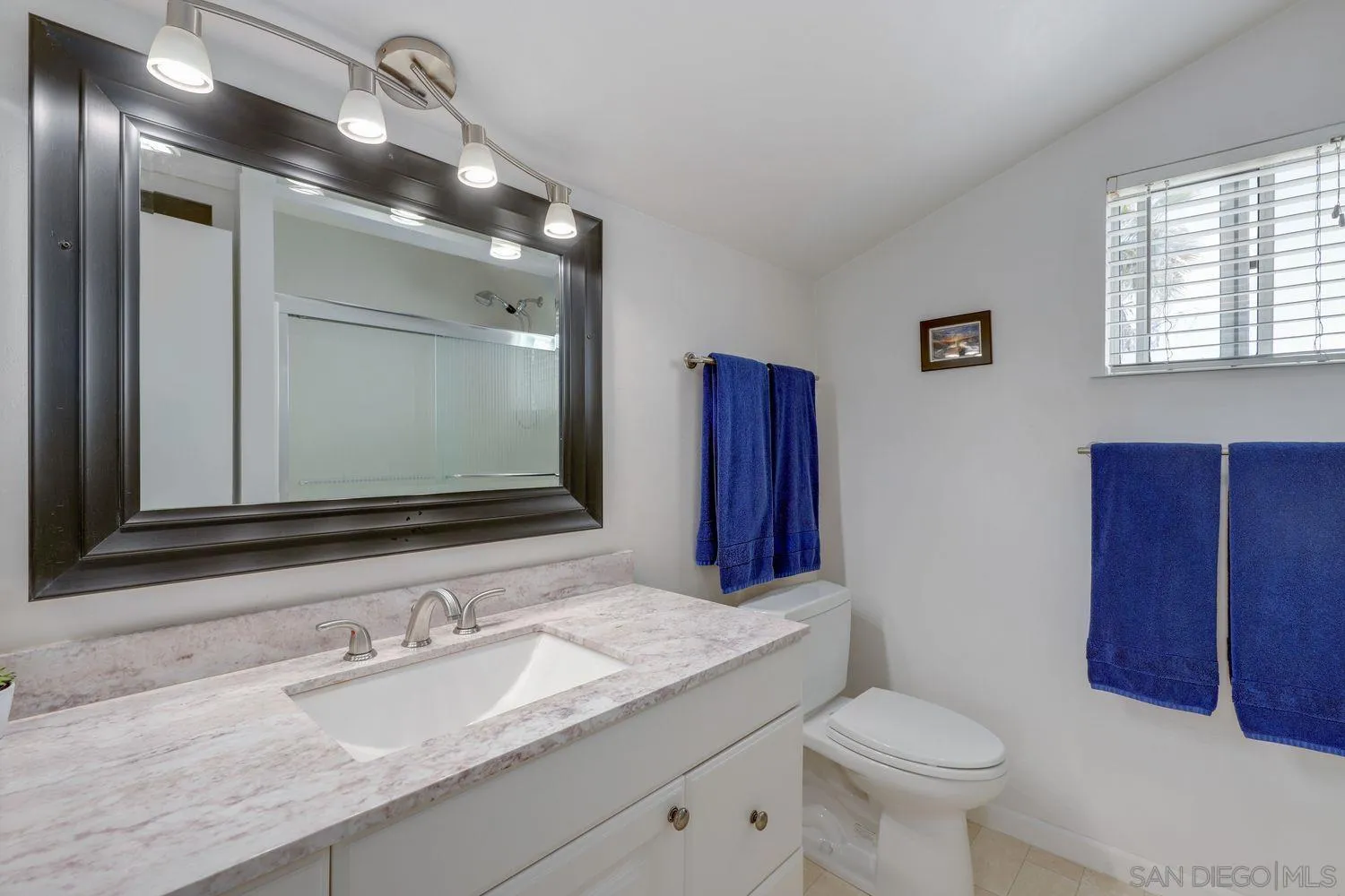 8531 Menkar Road San Diego, CA 92126 - Photo 22 of 37 a bathroom with a granite countertop sink mirror vanity and toilet