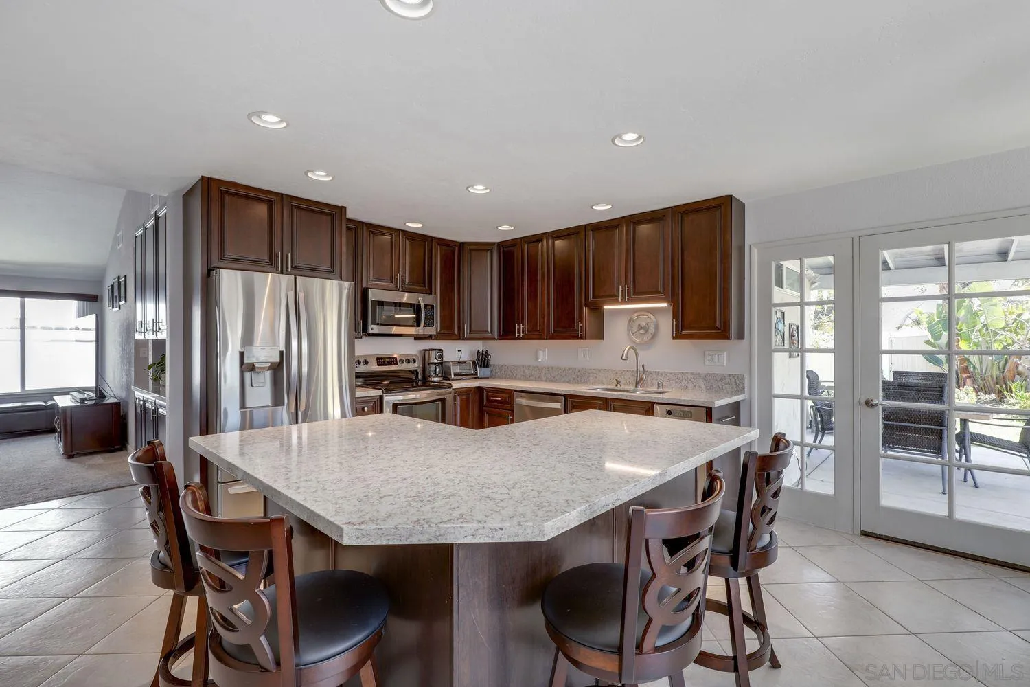 8531 Menkar Road San Diego, CA 92126 - Photo 7 of 37 a kitchen with granite countertop a dining table and chairs
