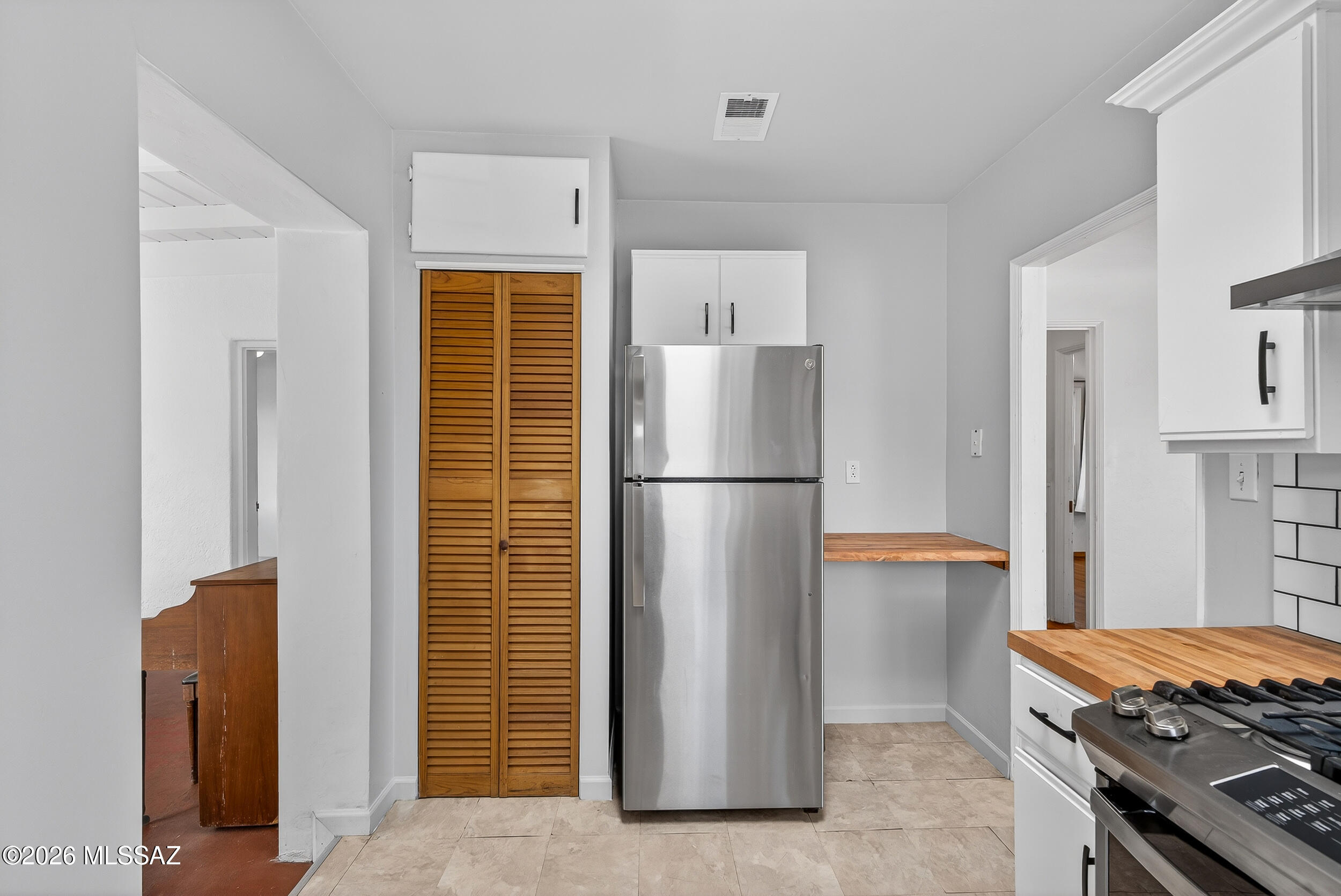 1412 East Spring Street Tucson, AZ 85719 - Photo 17 of 43 a kitchen with stainless steel appliances a refrigerator a stove and white cabinets