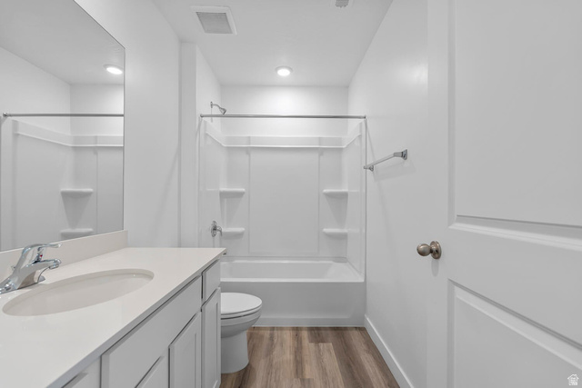2133 Wolverine Way, Unit 2440 Washington, UT 84780 - Photo 13 of 39 Bright bathroom featuring a single vanity with an integrated sink and chrome faucet, a tub/shower combination, recessed lighting, and wood-finish flooring