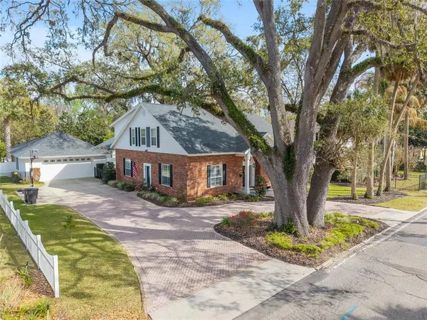 a front view of a house with a garden and trees