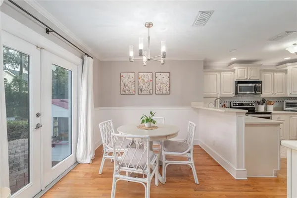 a view of a dining room with furniture a chandelier and wooden floor