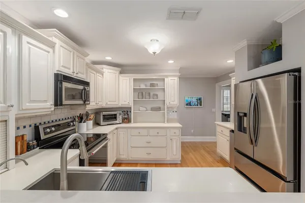 a kitchen with stainless steel appliances a stove a refrigerator and a sink