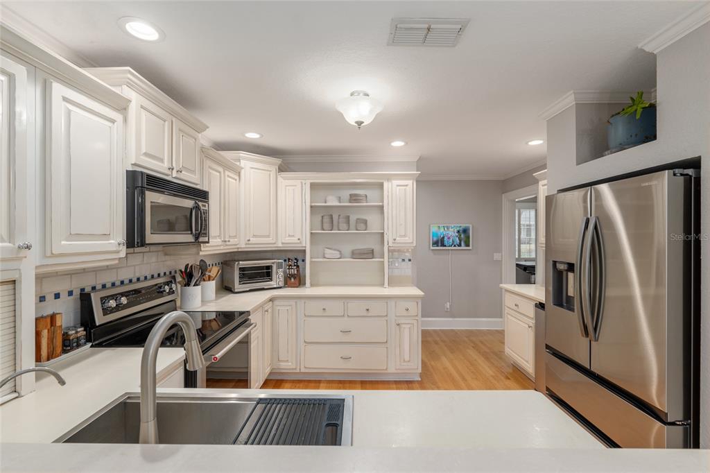 1107 Southeast 9th Avenue Ocala, FL 34471 - Photo 7 of 25 a kitchen with stainless steel appliances a stove a refrigerator and a sink