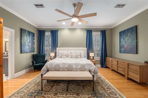 a bedroom with a bed mirror and a window
