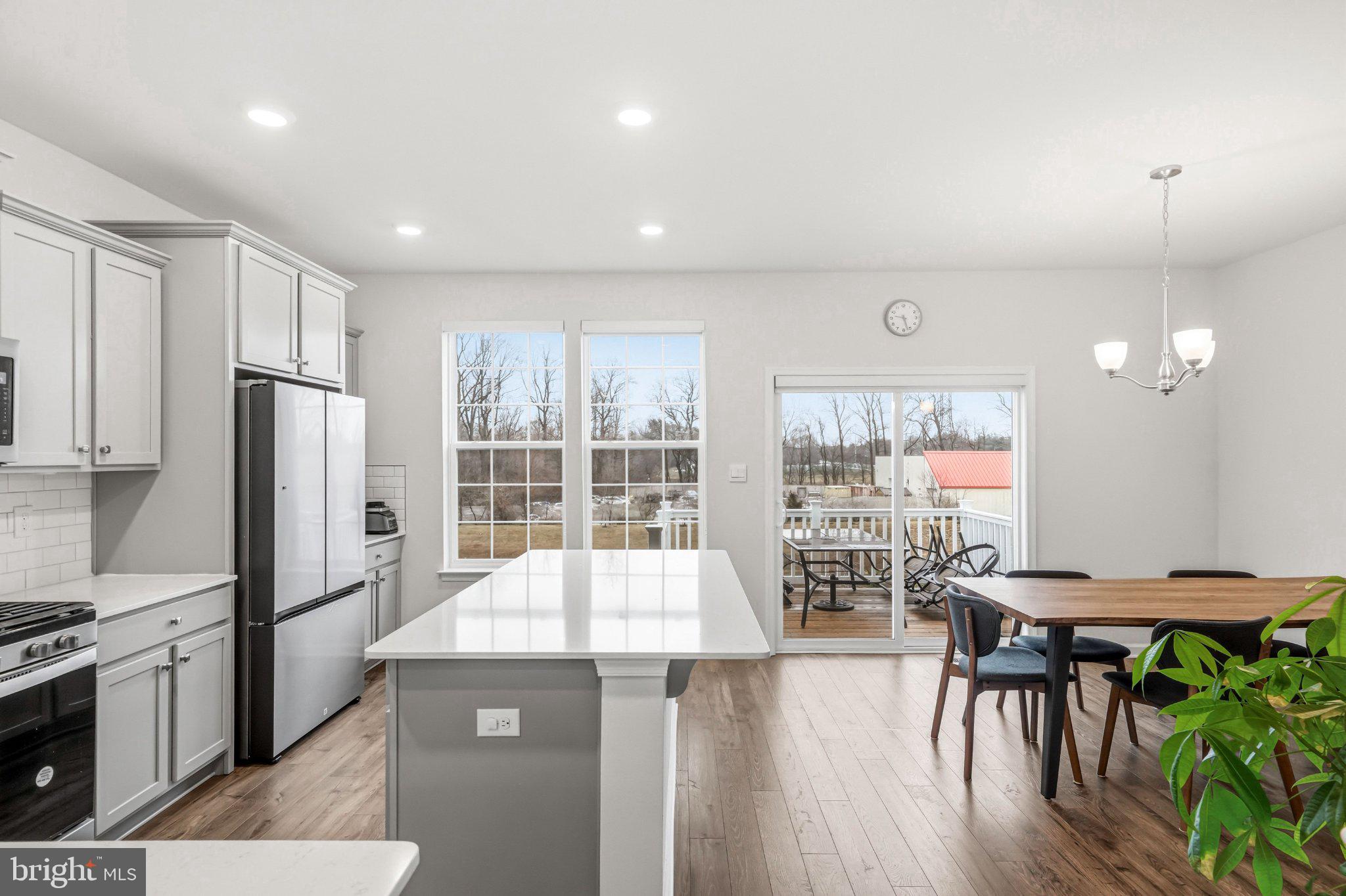 20 Sister's Farmstead Road Mount Laurel, NJ 08054 - Photo 25 of 42 a kitchen with stainless steel appliances granite countertop a stove top oven a refrigerator a dining table and chairs with wooden floor