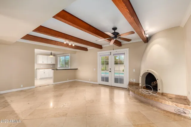 a view of an empty room with a windows and a ceiling fan