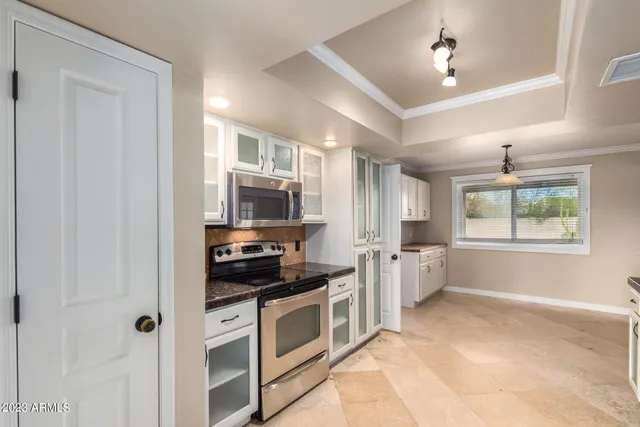 a kitchen with stainless steel appliances granite countertop a refrigerator and a stove