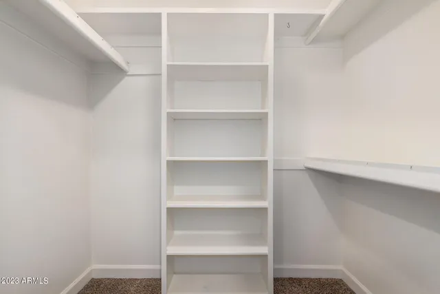 an empty room with a ceiling fan and a window