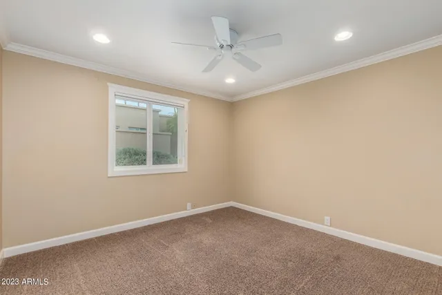 an empty room with a ceiling fan and a window