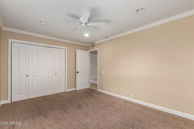 an empty room with windows and ceiling fan