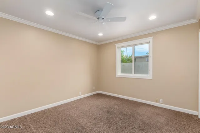 an empty room with fan closet and fan
