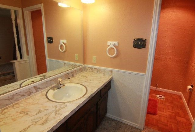 771 U.S. Highway 62 Ralls, TX 79357 - Photo 10 of 10 a bathroom with a granite countertop sink and a mirror