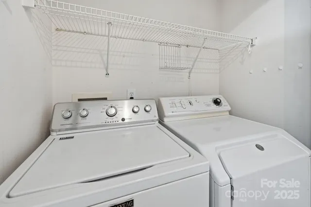 an empty room with windows and chandelier fan