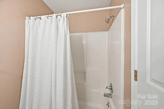 an empty room with windows and ceiling fan