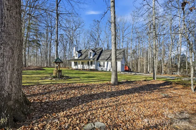 a view of a house with backyard and trees