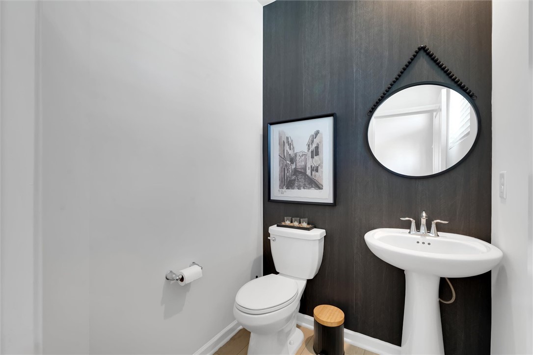 453 Bee Cv Way Pendleton, SC 29670 - Photo 11 of 25 A thoughtfully designed half-bathroom, showcasing a sleek toilet and pedestal sink for optimal space utilization.