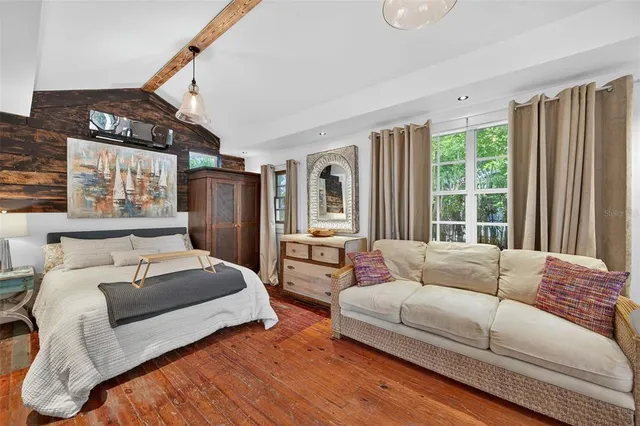 a bedroom with a bed window and table chair
