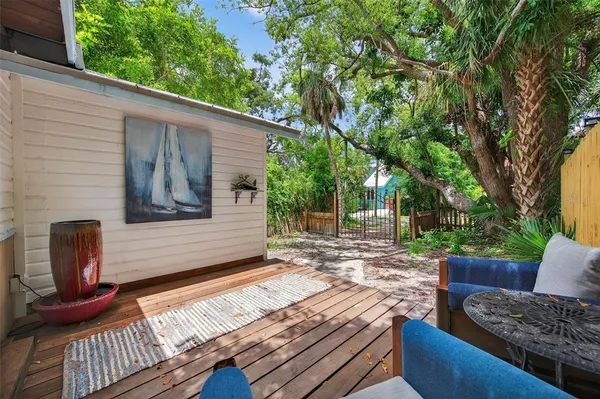a backyard of a house with large trees and wooden fence