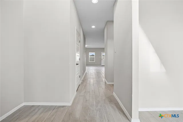 a view of a hallway with wooden floor