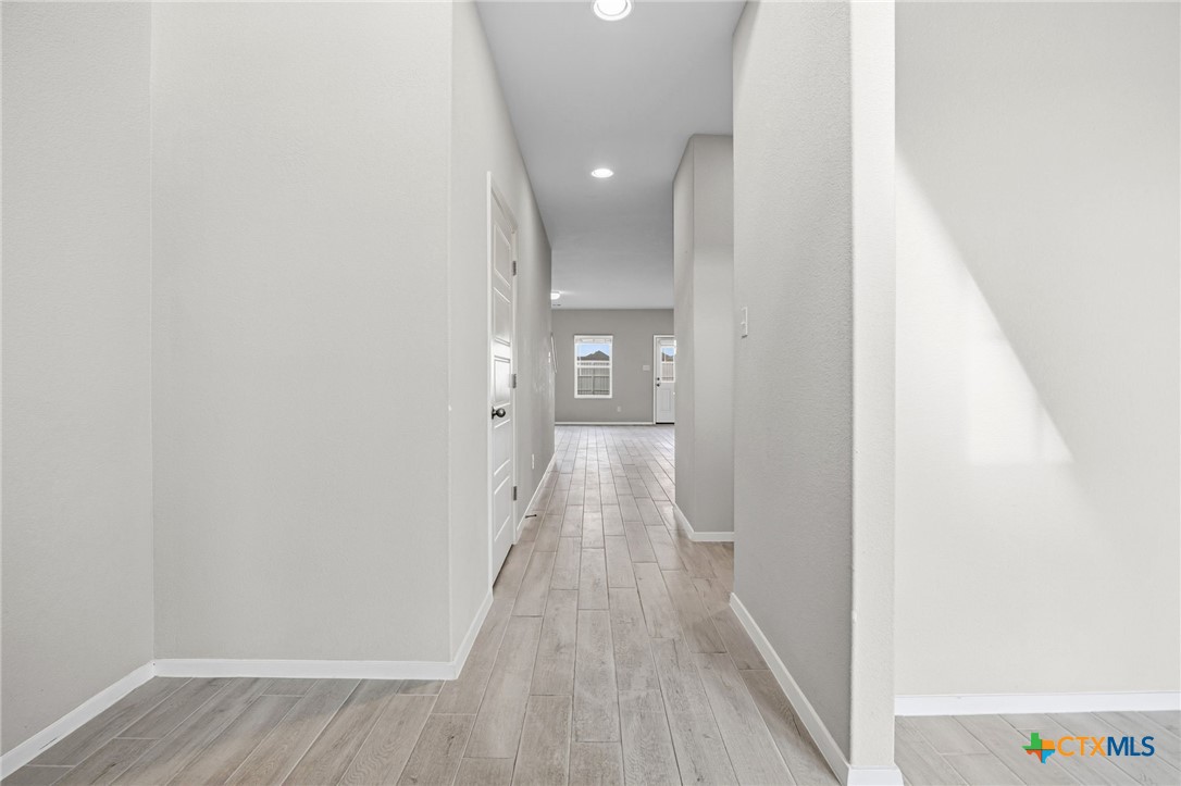 251 Chesterfield Drive Kyle, TX 78640 - Photo 5 of 24 a view of a hallway with wooden floor