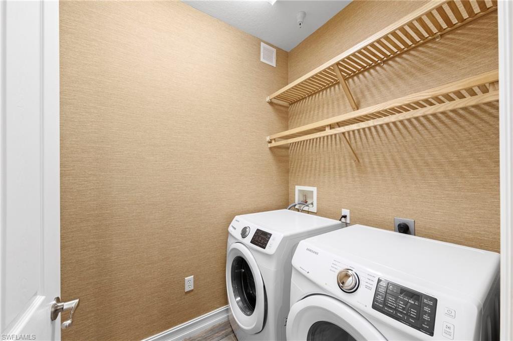 9076 Rialto Street, Unit 6204 Naples, FL 34113 - Photo 21 of 50 Dedicated laundry area featuring textured wall finish, wood-finish shelving, and wood-finish flooring. NEW TILE FLOOR (2018), NEW WASHER/DRYER (2018), NEW WALLPAPER (2018)