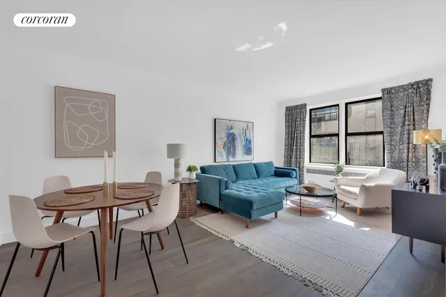 a living room with furniture kitchen view and a large window