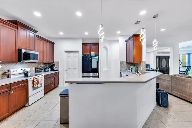 a large kitchen with stainless steel appliances lots of counter space and a sink