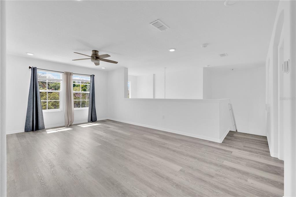 3480 Pawleys Loop North St. Cloud, FL 34769 - Photo 7 of 25 a view of an empty room with window and wooden floor