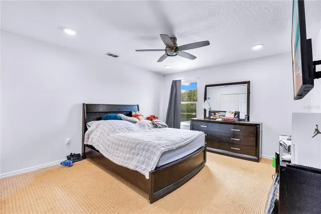 a bedroom with a bed and a mirror on the dresser