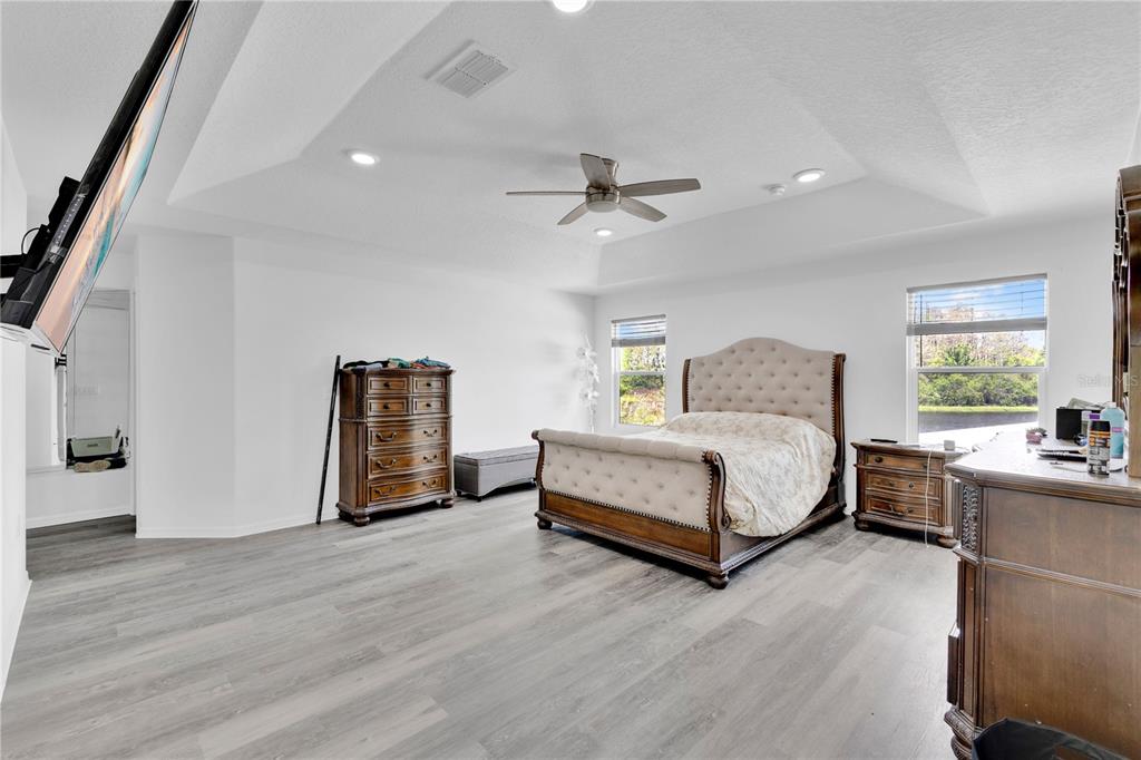 3480 Pawleys Loop North St. Cloud, FL 34769 - Photo 9 of 25 a spacious bedroom with a bed and a chandelier
