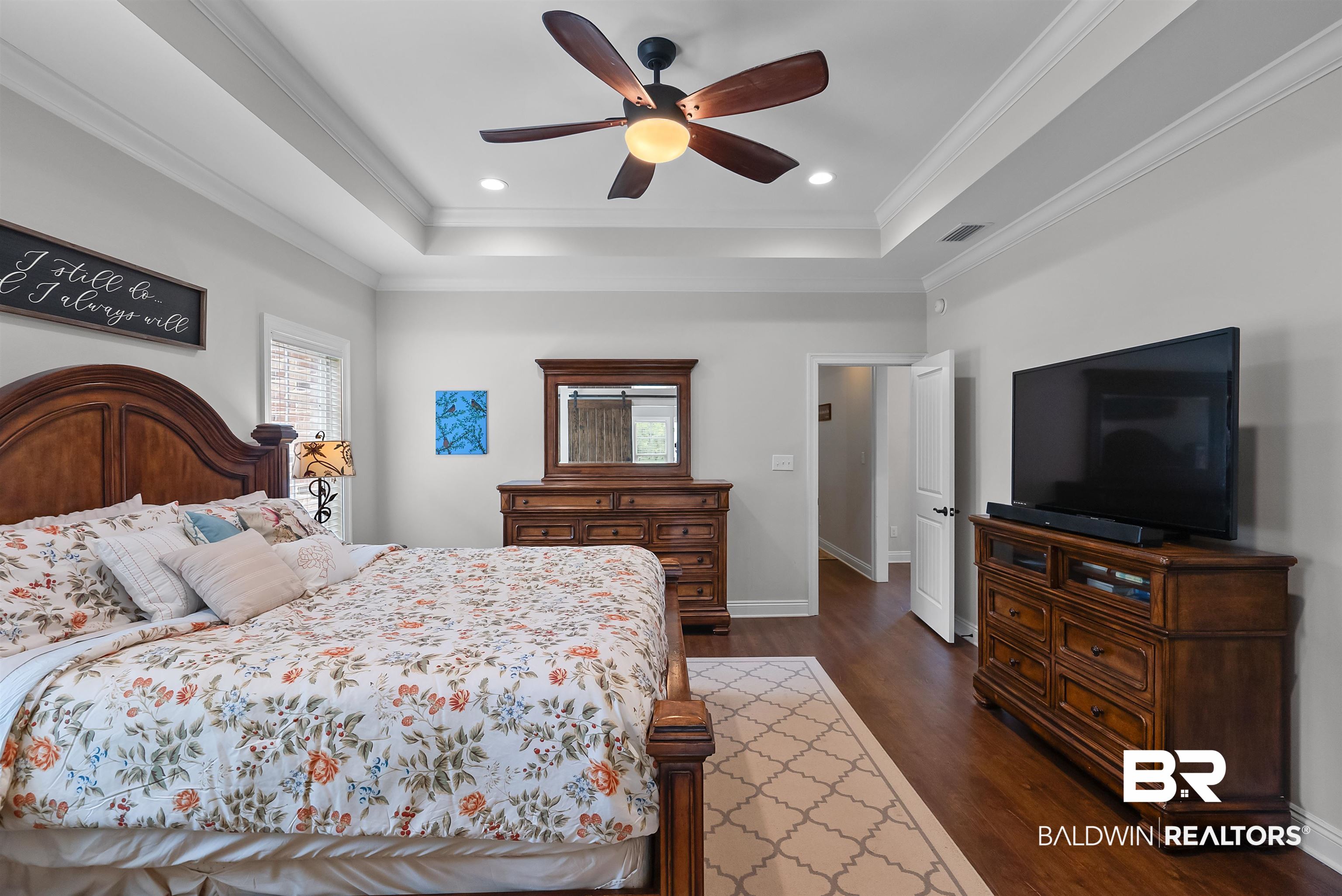 12070 Comalander Road Fairhope, AL 36532 - Photo 20 of 50 Spacious room featuring wood-finish flooring, a tray ceiling with crown molding, a ceiling fan with integrated lighting, and recessed overhead lighting