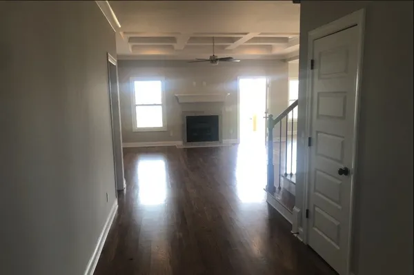 en empty room with wooden floor and a window