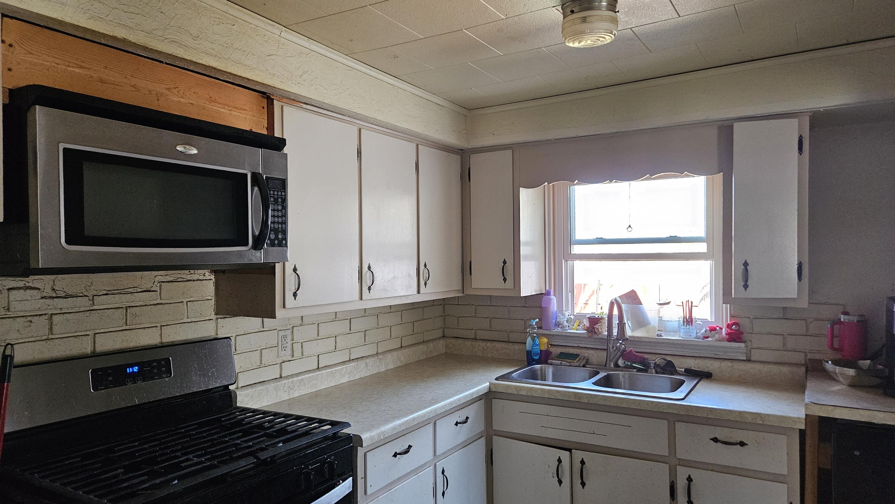 2700 Blake Road Portage, IN 46368 - Photo 2 of 8 a kitchen with a sink stove and microwave