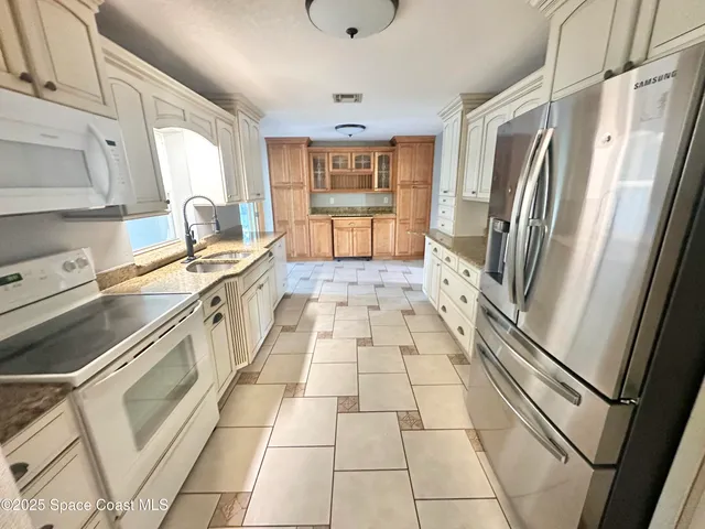 a large kitchen with a stove a refrigerator a sink and dishwasher