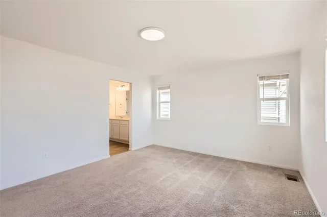 an empty room with windows and closet