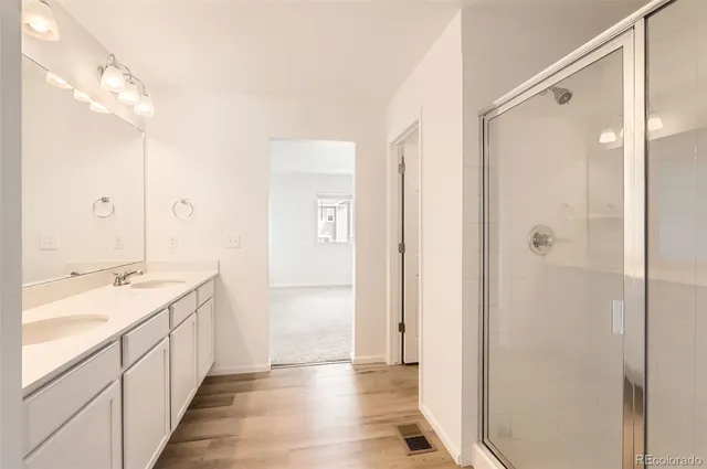 a bathroom with a double vanity sink and mirror with shower