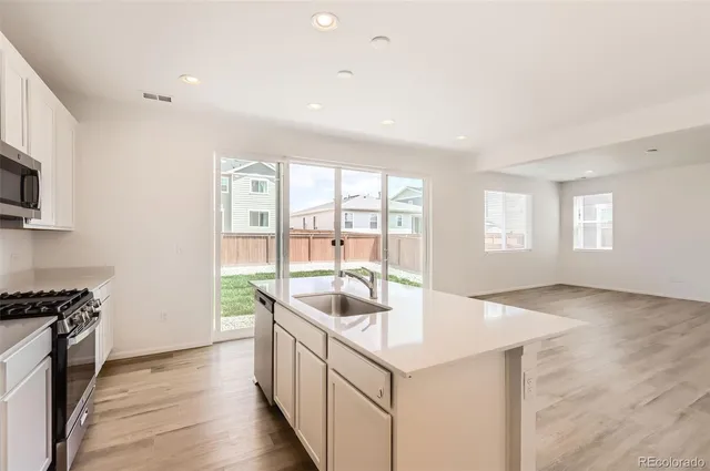 a kitchen with granite countertop a sink and a stove top oven