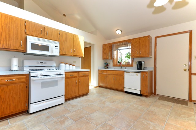 1710 Chestnut Hill Road Plainfield, IL 60586 - Photo 7 of 25 a kitchen with a stove top oven sink and cabinets