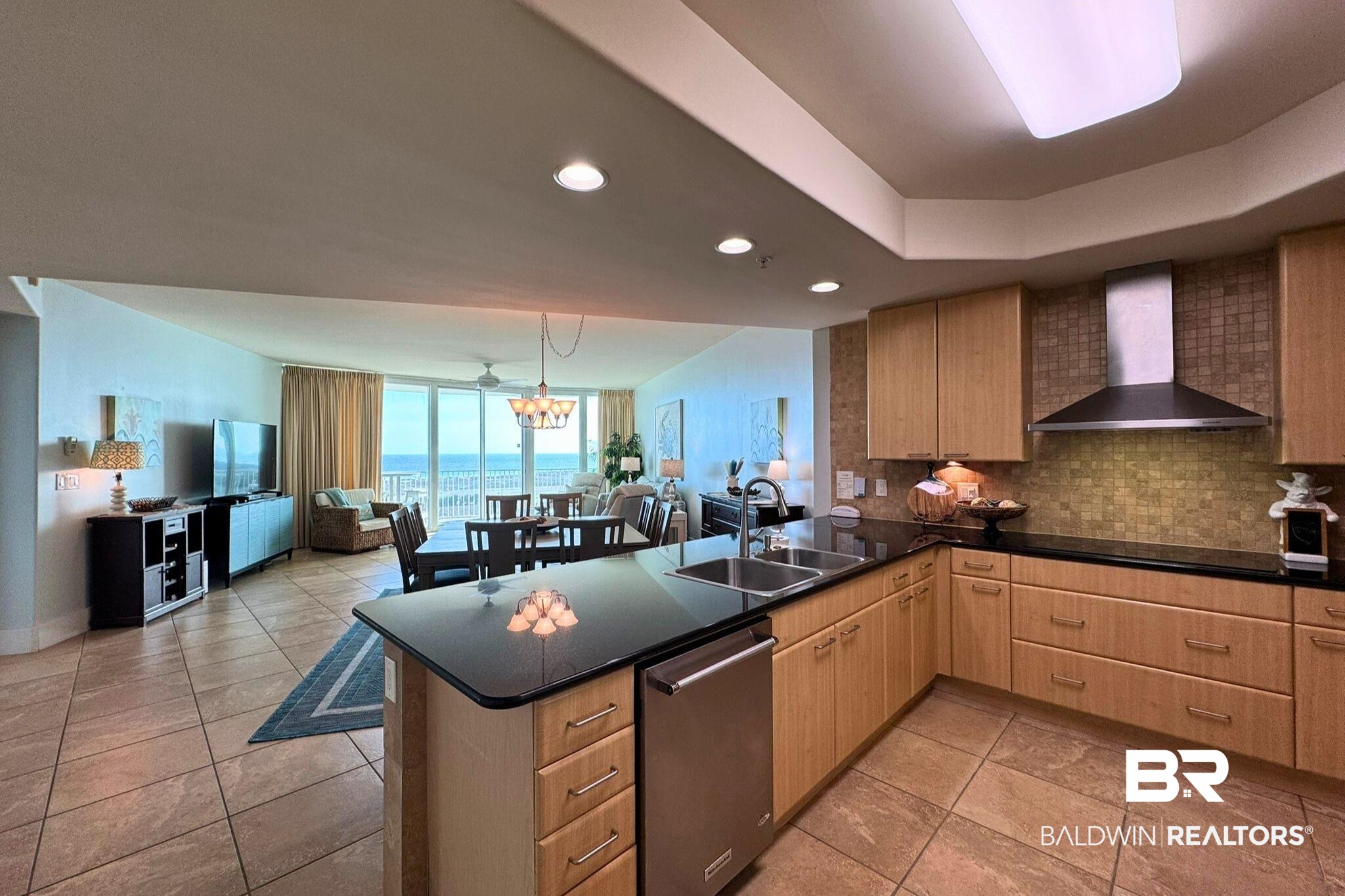 28107 Perdido Beach Boulevard, Unit D714 Orange Beach, AL 36561 - Photo 85 of 88 Kitchen with tasteful backsplash, open floor plan, stainless steel dishwasher, wall chimney range hood, and a sink