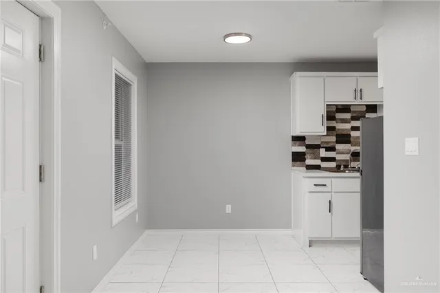 a kitchen with white cabinets and appliances