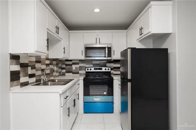 a kitchen with stainless steel appliances a stove a sink and a refrigerator
