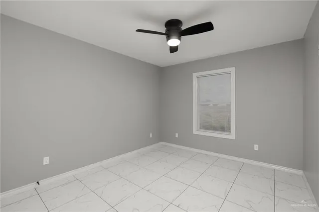 an empty room with ceiling fan and window