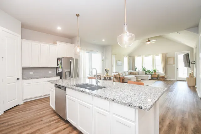 a kitchen with stainless steel appliances granite countertop a sink refrigerator and cabinets