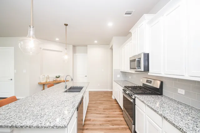 a kitchen with sink stove and refrigerator
